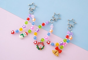 Detail view of handmade Christmas keychains with snowman, wreath and bell charms