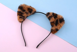 Close-up of cute plush cat ears headband with leopard print on a pink and blue background