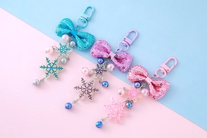 Close-up of sequin bow snowflake charms in blue, purple, and pink colors