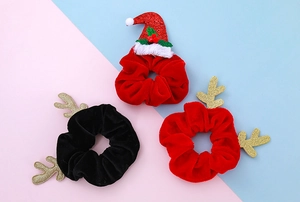 Detail von Weihnachts-Rentiergeweih und Weihnachtsmann-Mütze Samt-Haargummis auf Blau