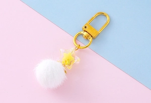 Detail of star acrylic pendant with white fluffy pompom and golden horseshoe buckle