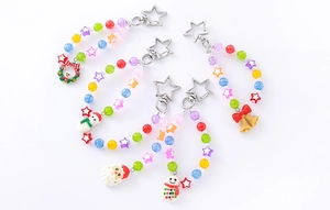 Macro detail of colorful acrylic beaded Christmas keychains with snowman and bell charms