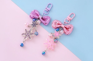 Close-up of sequin bows and transparent snowflake charms on cute keychain pendants