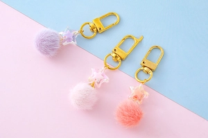 Three plush star keychains in pastel colors with golden metal lobster clasps