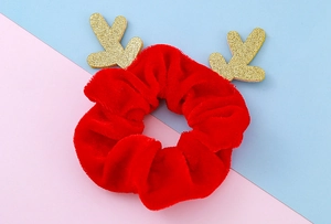 Detailansicht des roten Samt-Weihnachtshaargummis mit funkelndem goldenem Glitzer-Rentiergeweih
