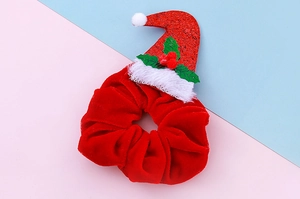 Detailansicht eines roten Samt-Weihnachtshaargummis mit Mini-Weihnachtsmütze und Glitzer