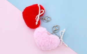 Detail of plush heart keychain with imitation pearl bow and silver lobster clasp