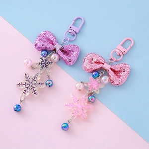 Sparkly sequin bow and snowflake charm keychains in lavender purple and sakura pink