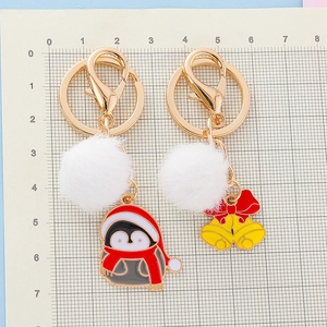 Porte-clés de Noël pingouin et cloche avec pompon blanc sur tapis de mesure