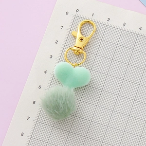 Portachiavi con pompon a cuore verde menta e chiusura a moschettone dorata su scala