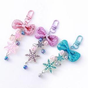 Sparkly bow and snowflake keychain set in pink, purple, and blue pastel colors