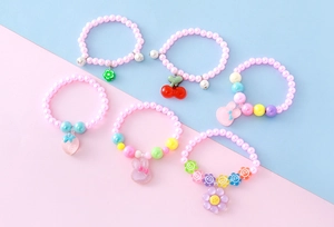 Détail de bracelets de perles pour enfants avec pendentifs mignons en résine de fruits