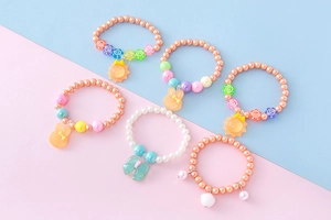 Détail de six bracelets en perles de résine avec breloques mignonnes pour filles