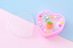 Nahaufnahme von Kinder-Schmuckset mit Erdbeer- und Blumenperlen in Herzbox-Verpackung