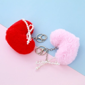 Red and pink plush heart keychains with faux pearl bows and silver metal clasps