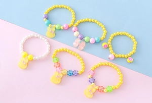 Lot détaillé de six bracelets en perles de résine colorées avec pendentifs animaux