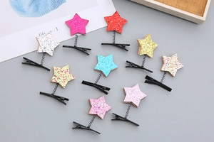 Close-up of colorful glitter star hair clips with metal springs and duckbill bases