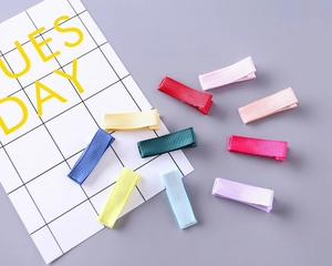 Detailoverzicht van tien kleurrijke met grosgrain lint omwikkelde haarklemmen voor DIY-werk