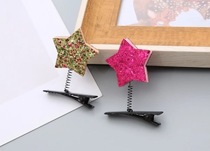 Détail de barrettes à cheveux étoiles pailletées avec ressort et base en métal noir
