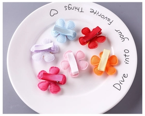 Close-up of 6 colorful fabric flower hair clips with ribbon wrapped metal duckbill clips