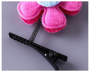 Détail macro d'une barrette à ressort en feutre bicolore rose et bleu pour petites filles