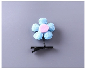 Détail de la pince à cheveux fleur en feutrine bleue avec centre rose et ressort