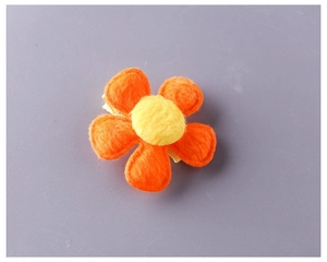 Detailed macro view of orange plush five-petal flower hair clip for girls and babies