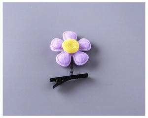 Détail d'une pince à cheveux fleur en feutre jaune et violet avec ressort et clip crocodile