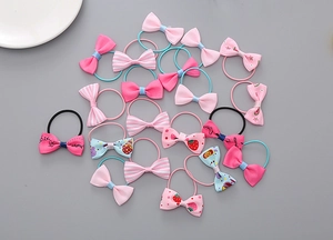 Close-up of children's elastic hair ties with colorful bowknots and strawberry patterns