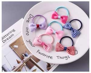 Close-up of floral and plaid bow hair ties in a ceramic dish with high-elastic bands