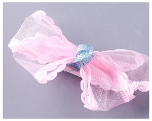 Close-up of pink mesh bow hair clip with blue glitter center and lace wave edges