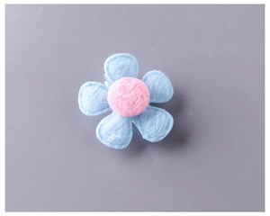 Close-up of sky blue plush flower hair clip with pink center and fabric covering