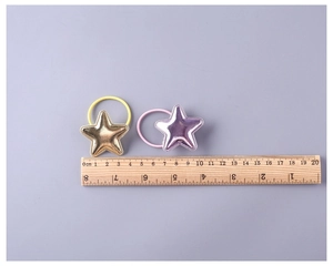 Detailed close-up of a padded PU leather star hair tie with metallic finish and elastic band