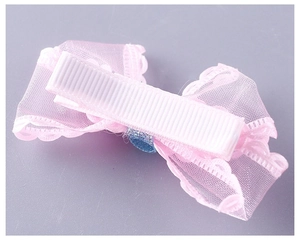 Close-up of pink mesh bow hair clip with safe fabric-covered clip for girls