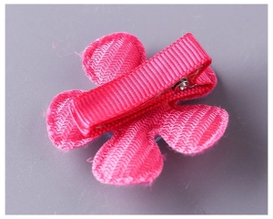 Detail of rose pink fabric flower hair clip with ribbon-wrapped safety metal base