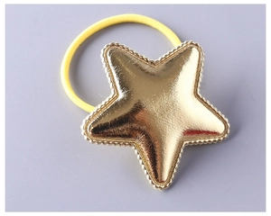 Detail of yellow elastic hair tie featuring a metallic gold PU star with stitched edges