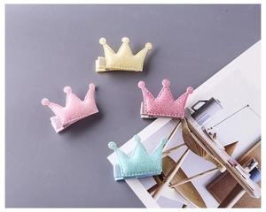 Détail de quatre pinces à cheveux couronne pailletées en jaune, rose, rouge et vert