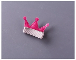 Détail d'une pince à cheveux couronne rose avec tissu chevron et ruban gris soigné