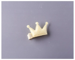 Détail d'une barrette couronne jaune pailletée pour enfants avec base en tissu doux