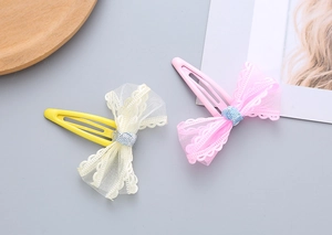 Detailed view of handmade lace bow hair clips in pink and yellow for girls