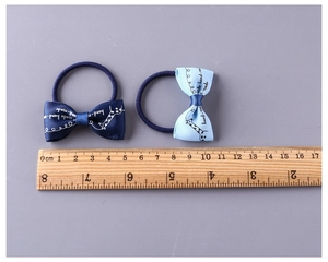 Detail showing two candy-colored bow hair ties with giraffe print and size measurement