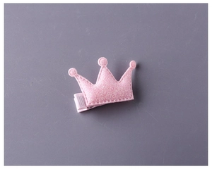 Détail d'une barrette couronne rose pailletée pour fille avec revêtement en tissu