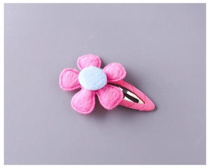 Close-up of pink fabric flower hair clip for girls with ribbed ribbon safety wrap