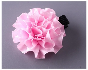 Dettaglio di un fermaglio per capelli a fiore in nastro rosa fatto a mano con clip