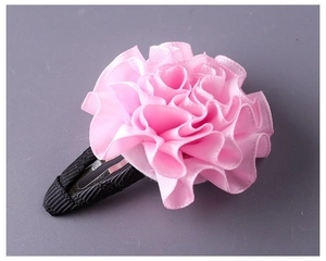 Dettaglio di un fermaglio per capelli a fiore in nastro rosa fatto a mano con petali