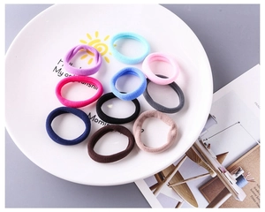 Vue à plat de chouchous colorés en nylon haute élasticité de 4 cm sur une assiette décorée