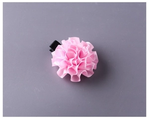 Dettaglio del fermaglio per capelli a fiore in nastro di seta rosa fatto a mano