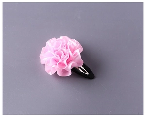 Dettaglio del fermaglio per capelli a fiore in tessuto rosa con clip BB nera