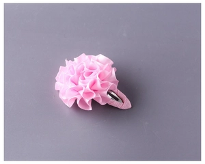 Dettaglio del fermaglio per capelli fatto a mano con fiore di nastro rosa