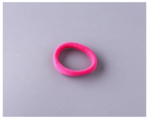 Gros plan sur un élastique à cheveux rose vif en tissu éponge avec texture tricotée